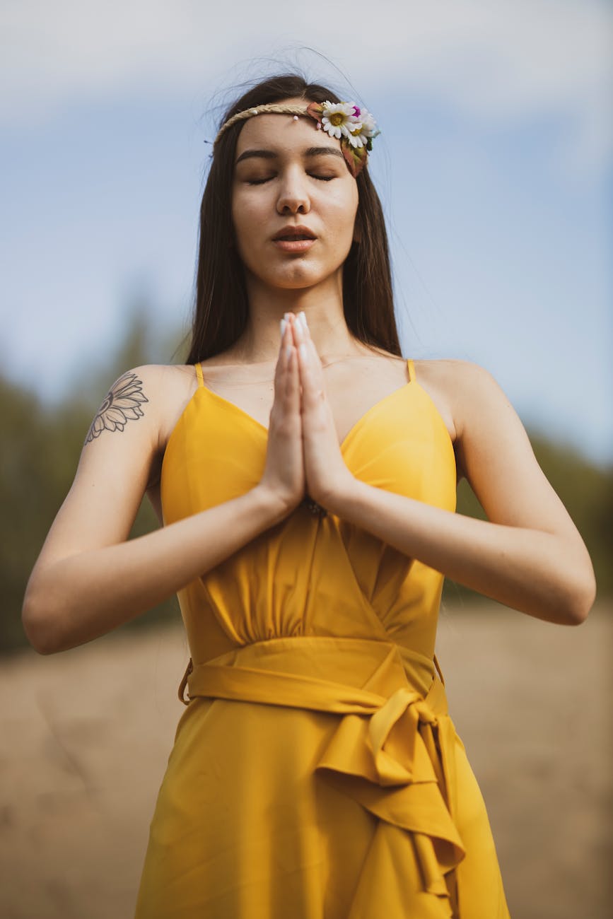 woman in yellow dress in a praying position